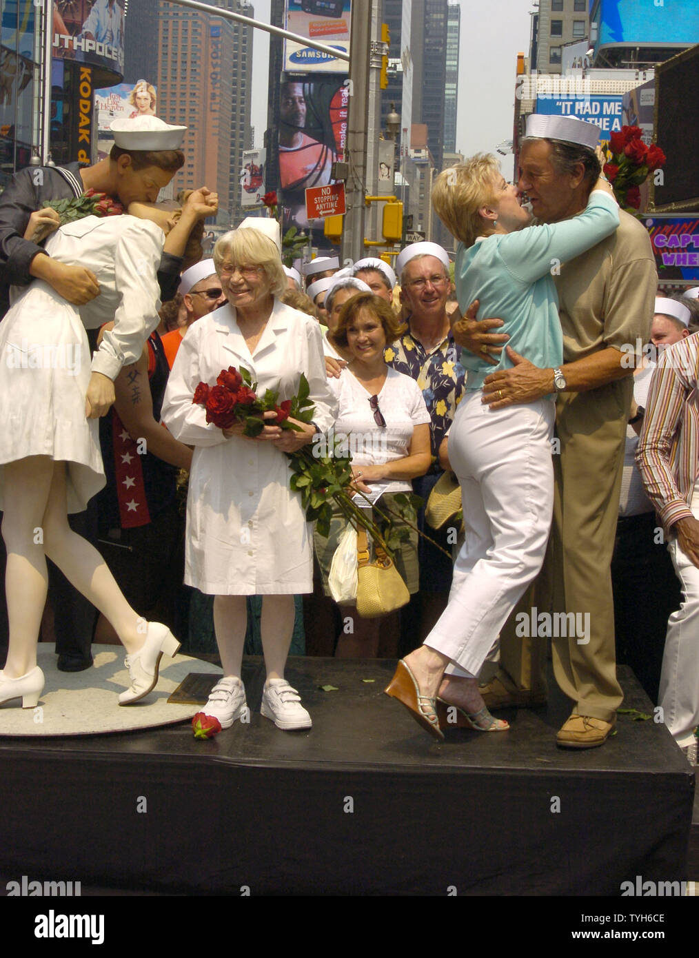 Edith Shain and Carl Muscarello, who gets a kiss from wife Shelly, are shown next to the Unconditional Surrender Sculpture at the 60th Anniversary of the end of World War II in Times Square on August 14, 2005.  They were recreating the famous pose from the Alfred Eisenstadt photograph celebrating the Allied victory in the war. They claim to be the original couple in the photograph.   (UPI Photo/Robin Platzer) Stock Photo