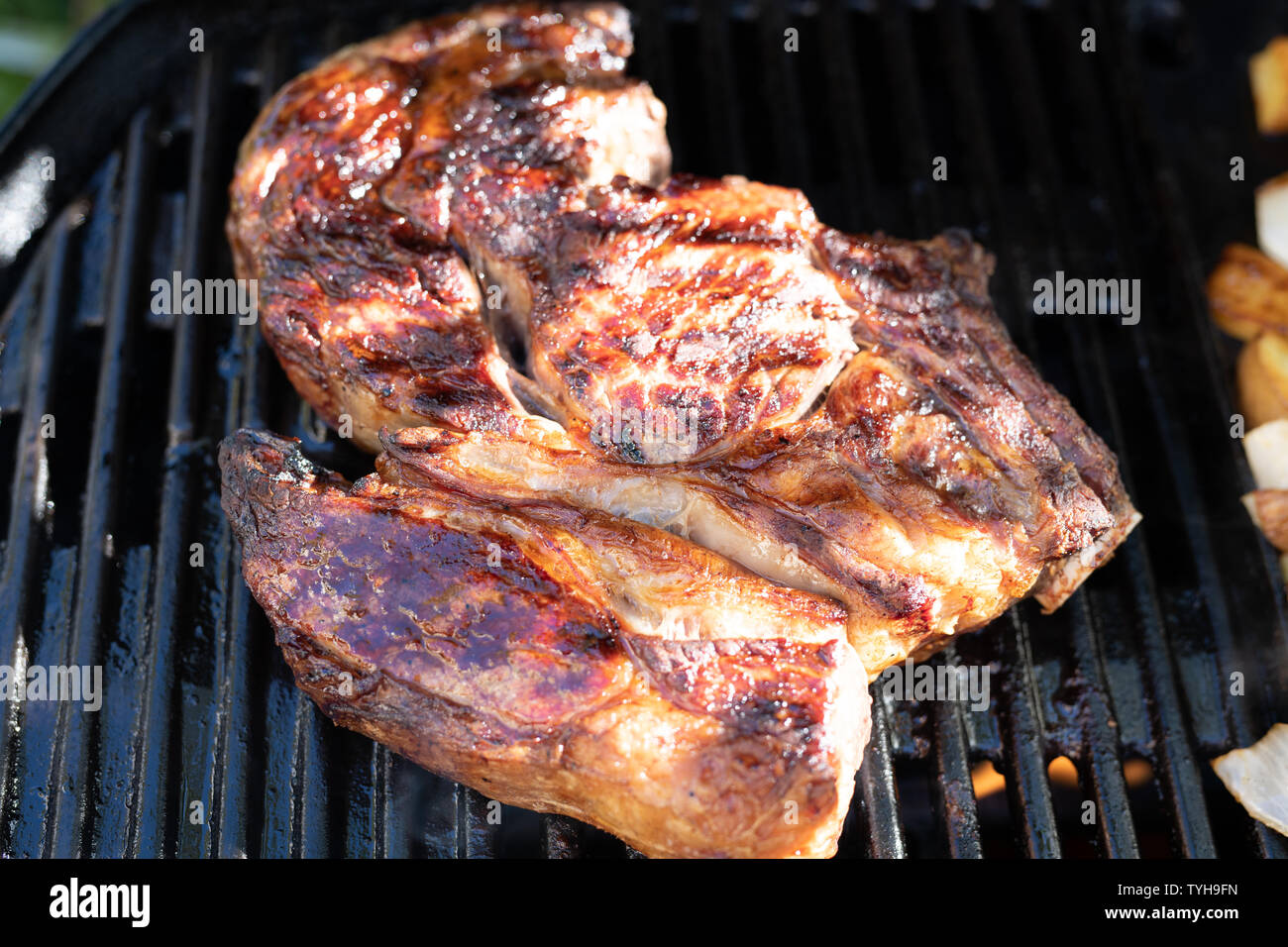 Joint of beef cooking on an outdoor grill Stock Photo