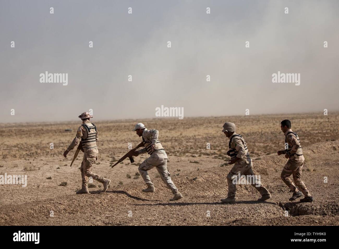 Iraqi security forces members advance to their next objective after breaching an obstacle during the combat engineer task training course at the Besmaya Range Complex, Iraq, Nov. 9, 2016. Camp Besmaya is one of four Combined Joint Task Force – Operation Inherent Resolve (CJTF-OIR)building partner capacity locations dedicated to training Iraqi security forces. Combined Joint Task Force-Operation Inherent Resolve is a multinational effort to weaken and destroy Islamic State in Iraq and the Levant operations in the Middle East region and around the world. Stock Photo