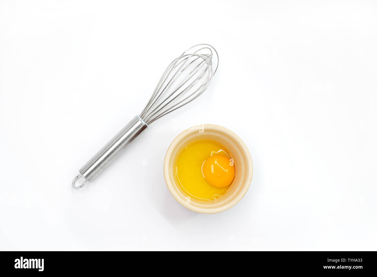 Top view of an egg yolk and whisk on a white background Stock Photo Alamy