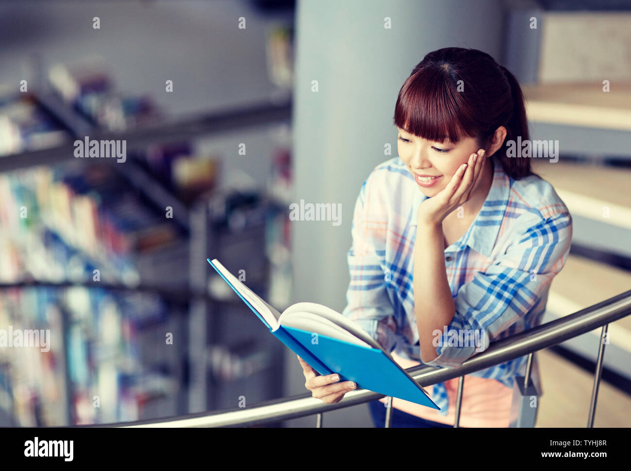 high school student girl reading book at library Stock Photo