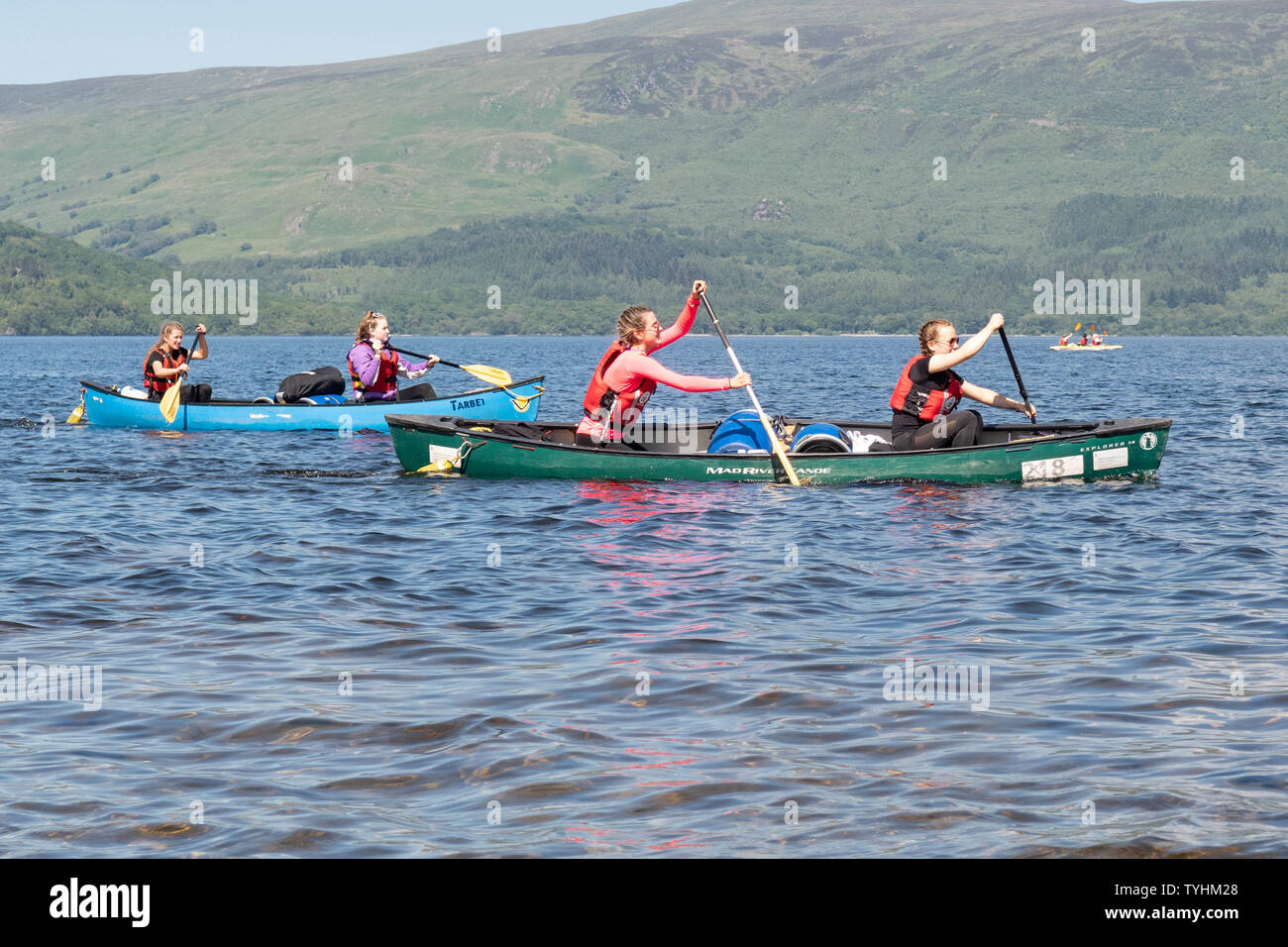 Luss, Loch Lomond, Scotland, UK. 26th June, 2019. UK weather - students from Hillpark Secondary School in Glasgow enjoying brilliant blue skies and bright sunshine this afternoon paddling on Loch Lomond for their Duke of Edinburgh silver expedition Credit: Kay Roxby/Alamy Live News Stock Photo