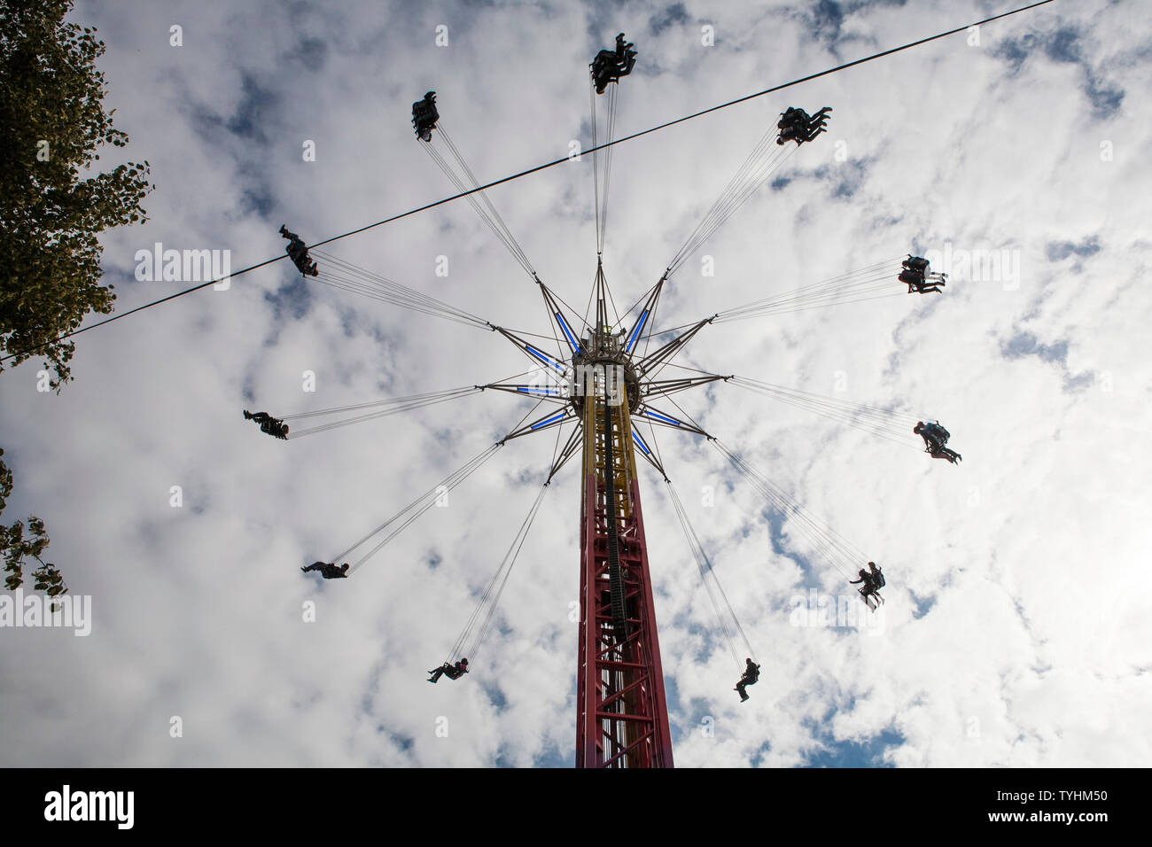 Passengers on a swing ride or chair swing ride with the London Eye in ...