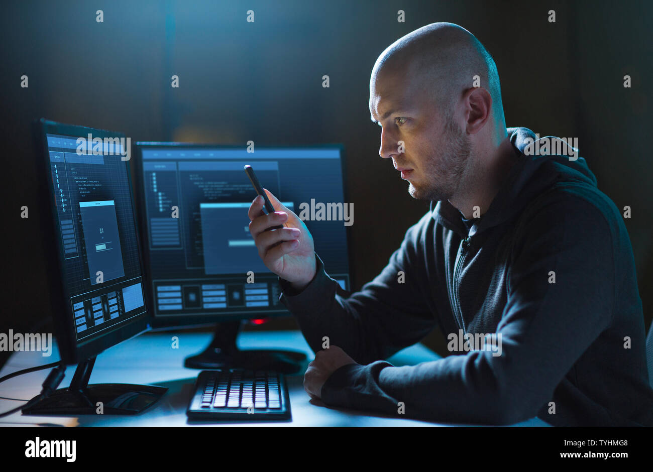 hacker with smartphone and computers in dark room Stock Photo - Alamy
