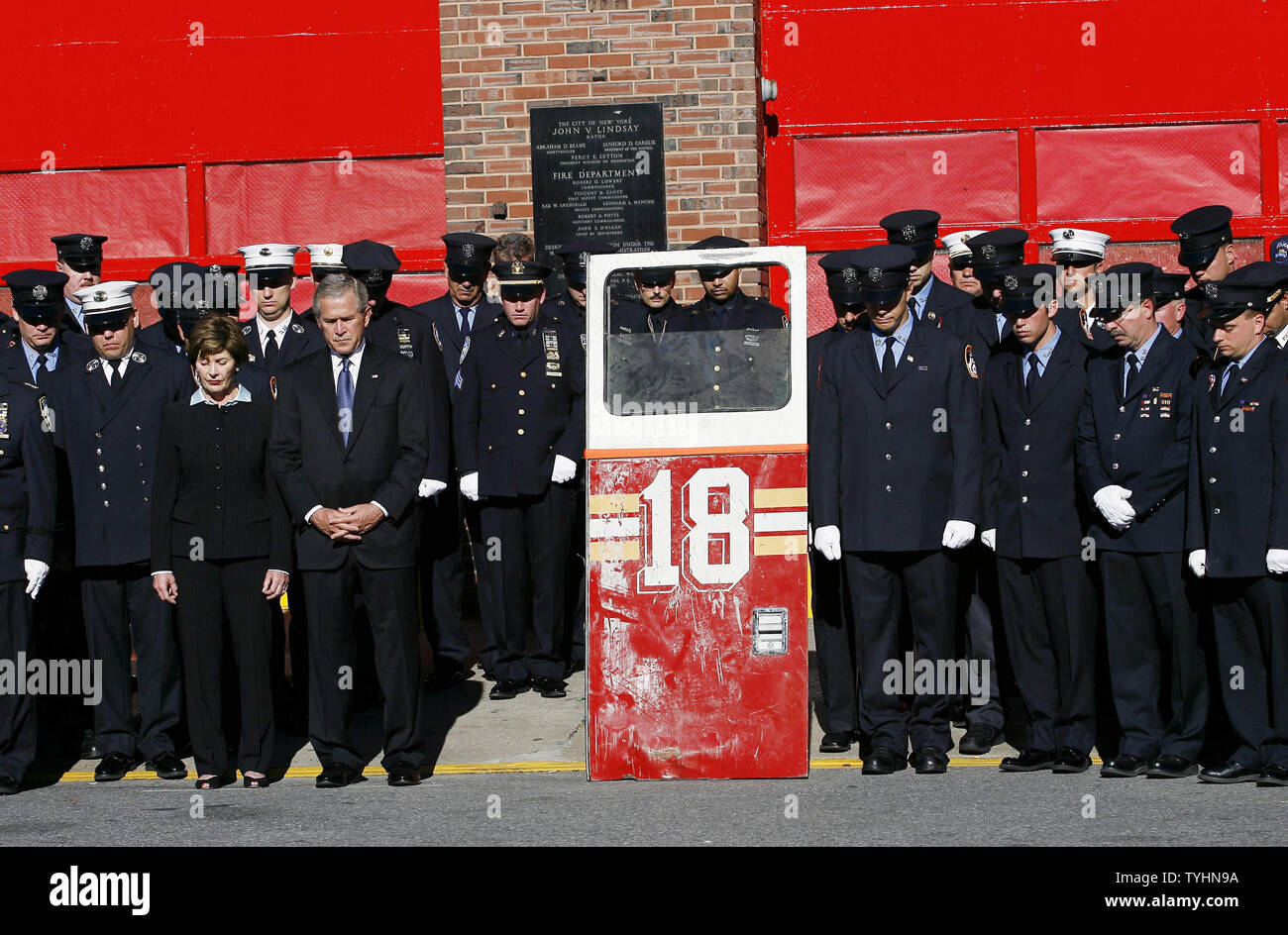 President George W. Bush and First Lady Laura Bush observe a moment of silence at the memorial ceremony at Fort Pitt Firehouse commemorating the fifth anniversary of September 11, 2001 in New York, NY on September 11, 2006.  The '18' door was on New York City's No. 18 Ladder Fire Truck that was destroyed when the World Trade Center towers collapsed. (UPI Photo/John Angelillo) Stock Photo