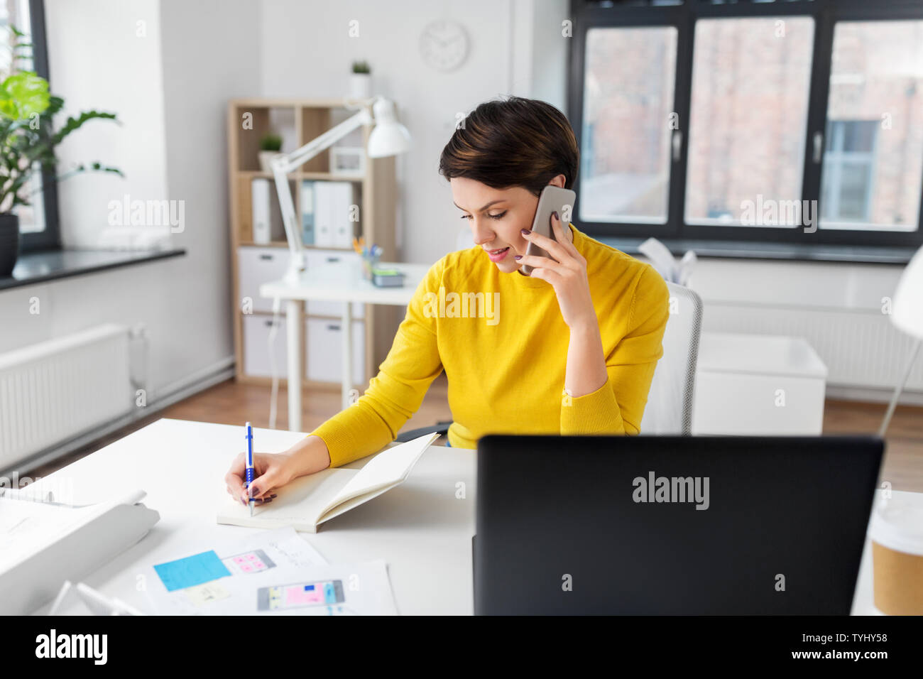 ui designer calling on smartphone at office Stock Photo