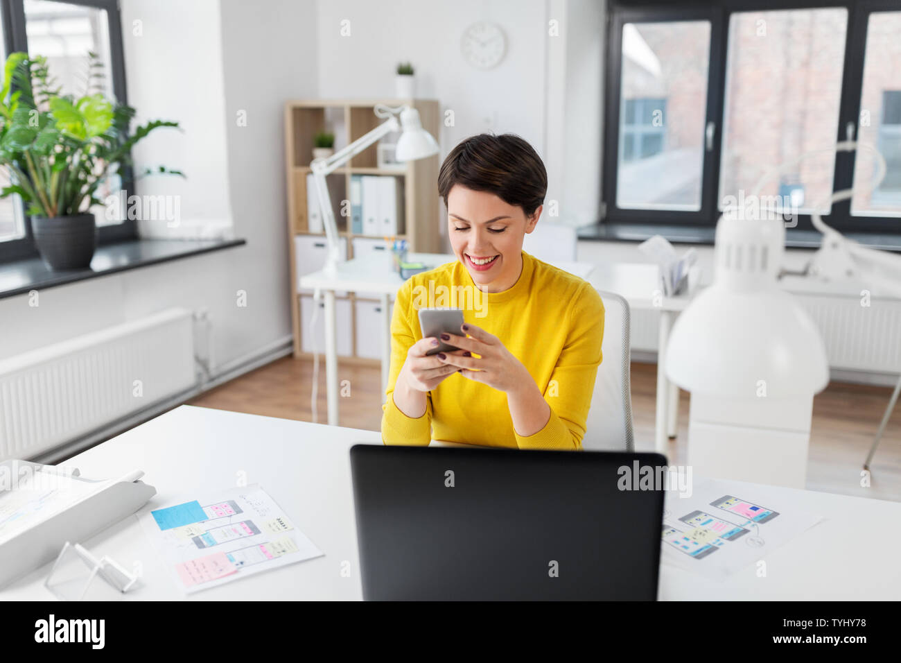 smiling ui designer using smartphone at office Stock Photo