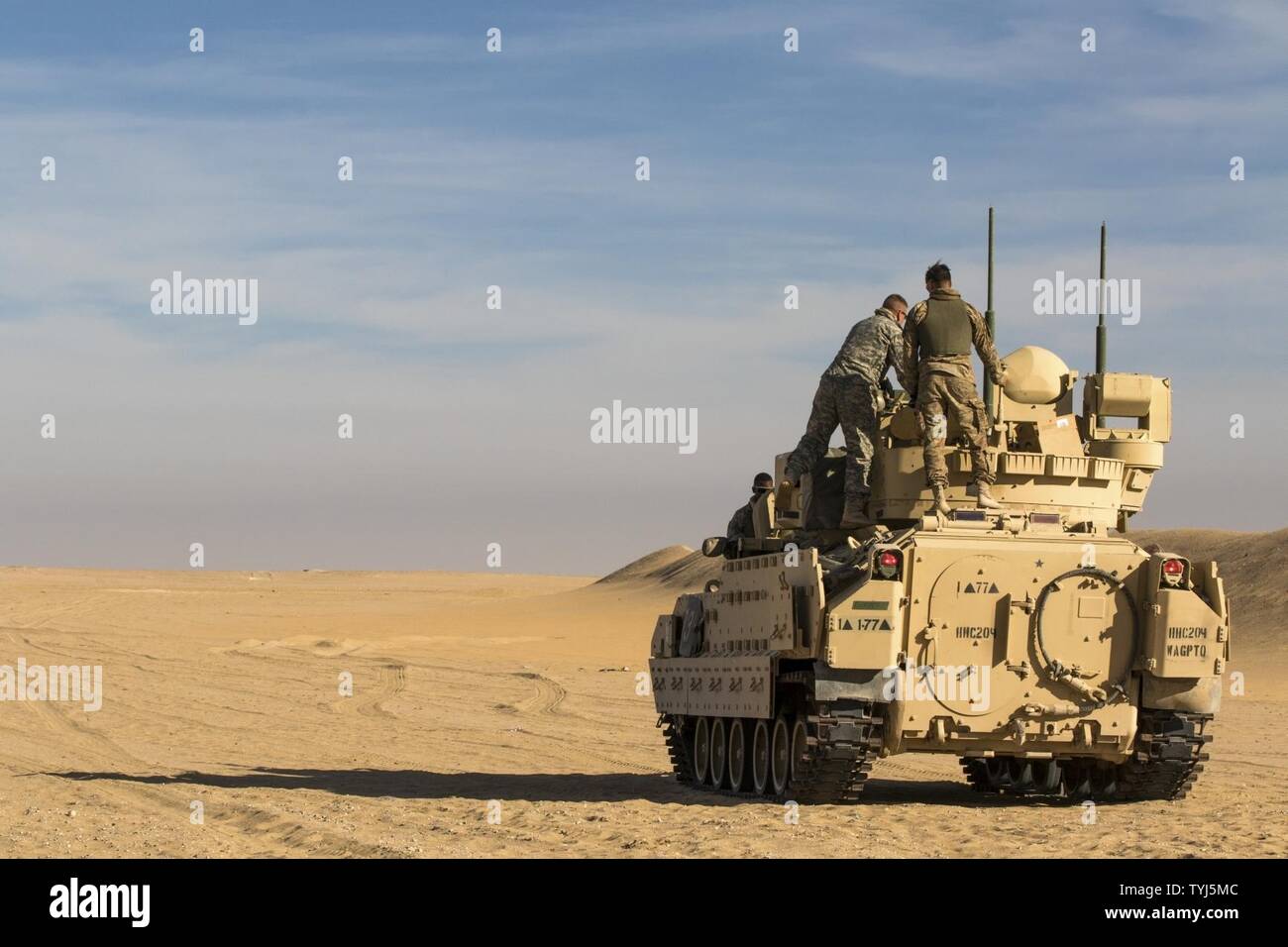 Cavalry Scouts from the 1st Battalion, 77th Armored Regiment mount a Bradley Fighting Vehicle at Udairi Training Range in Kuwait recently as part of a combined exercise. The Cavalry Scouts responded to contact with a notional enemy during the exercise, before providing critical intelligence for Soldiers from the 197th Field Artillery Brigade to provide fire support. Stock Photo