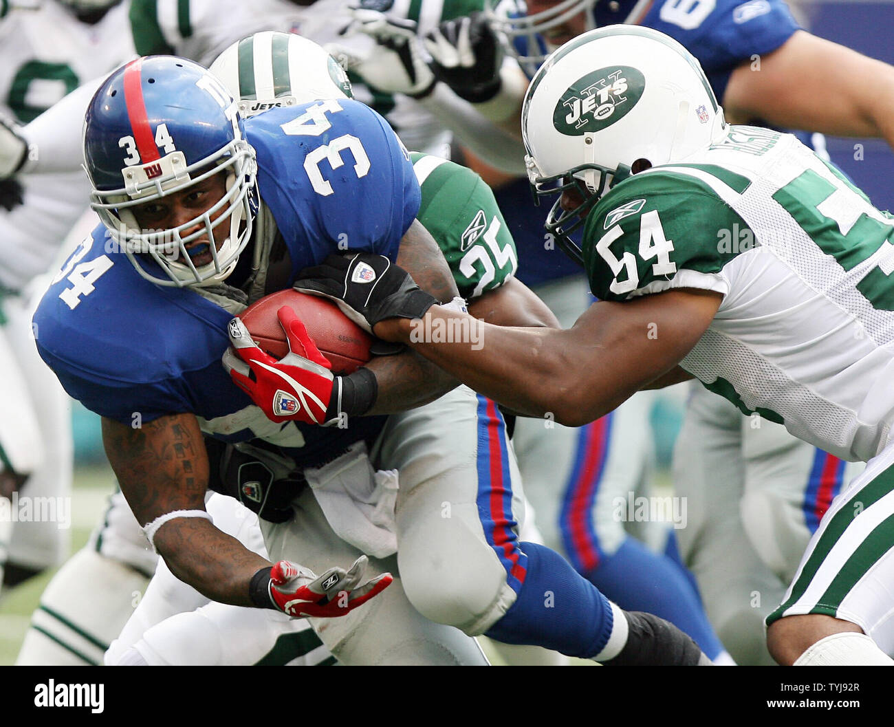 The New York Jets' Victor Hobson (54) tackles Miami Dolphins ball carrier Ronnie  Brown (23) during game action. The Jets defeated the Dolphins, 31-28, at  Giants Stadium in East Rutherford, New Jersey