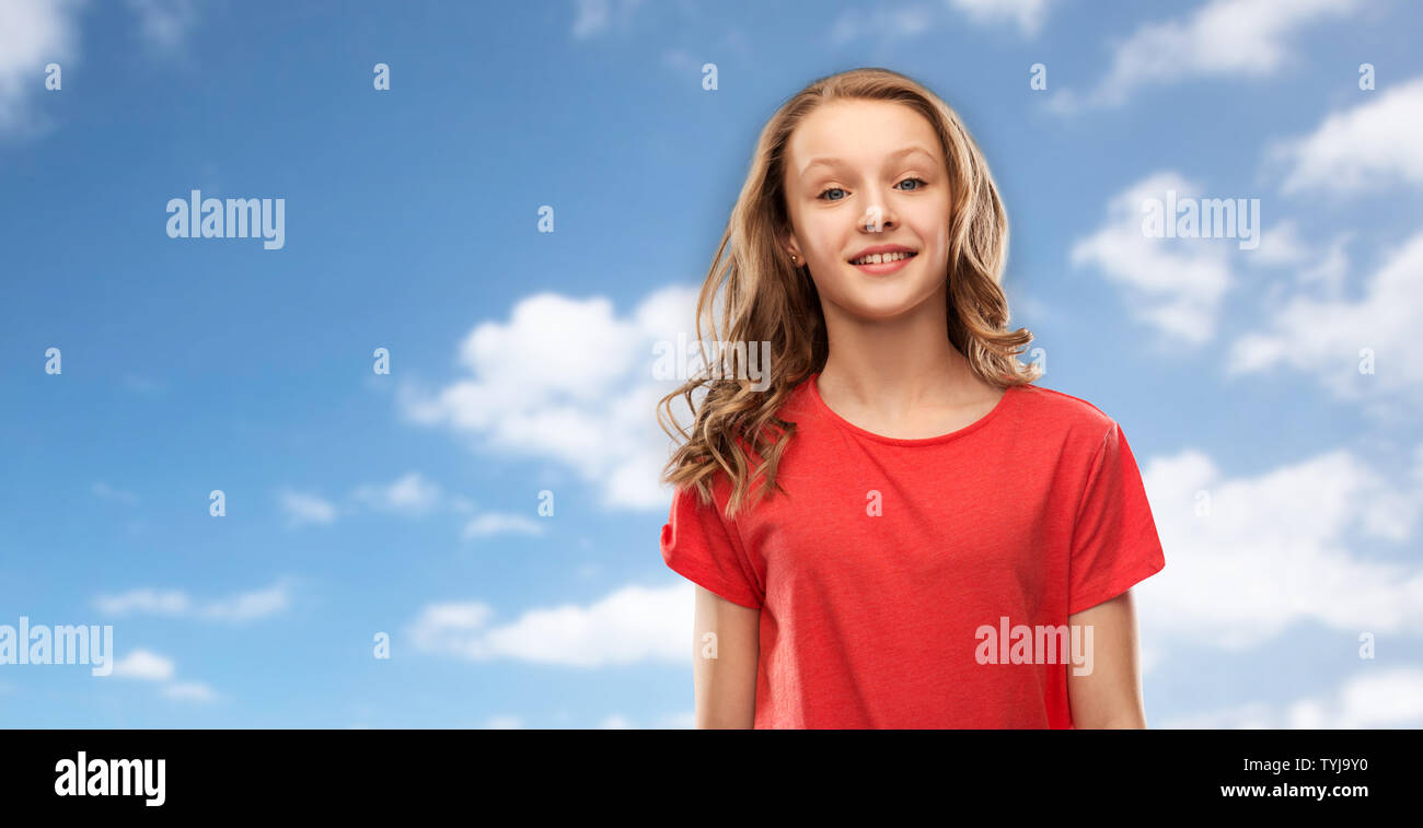 smiling teenage girl in red t-shirt over sky Stock Photo