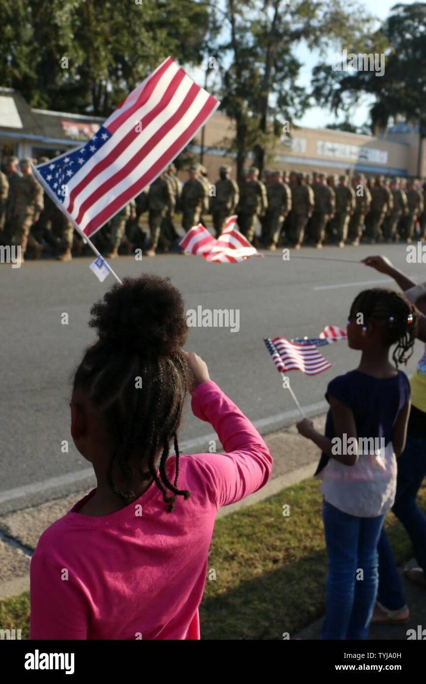 Children wave American flags as Soldiers of 3rd Infantry Division march past them during the Liberty County Veterans Day parade in Hinesville, Ga., November 11, 2016. The 3rd ID Soldiers represented active duty veterans during the parade. Stock Photo