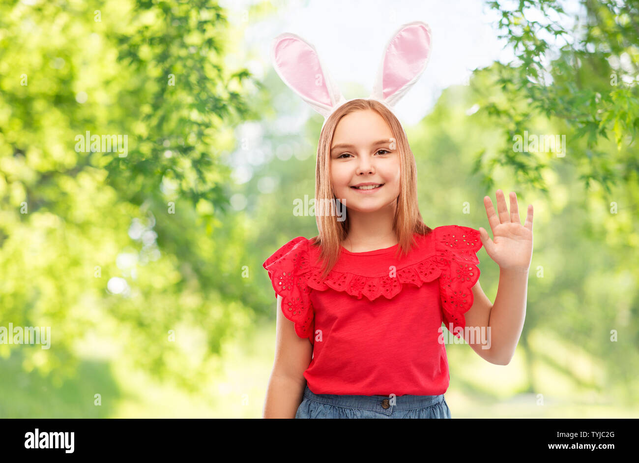 happy girl wearing easter bunny ears waving hand Stock Photo Alamy