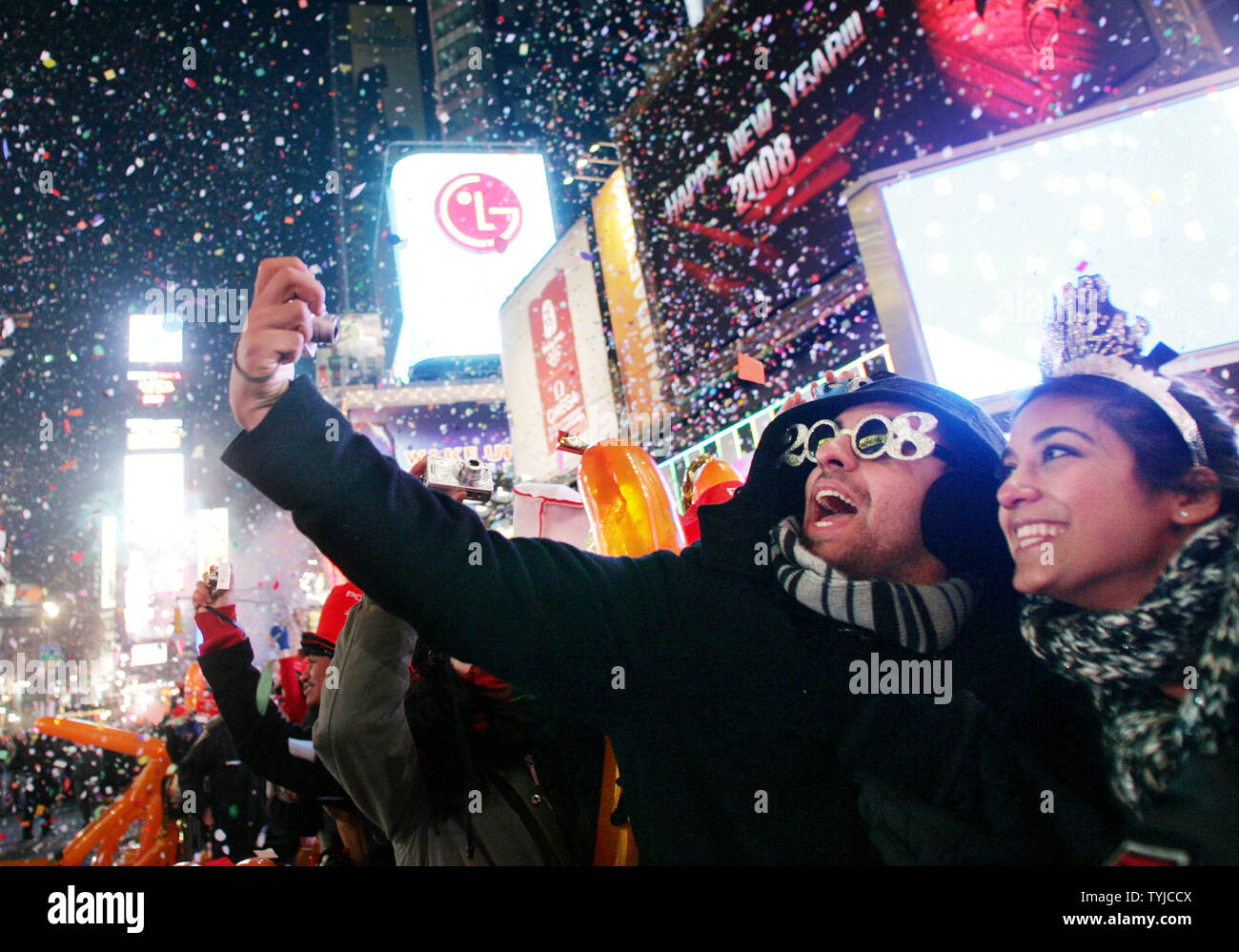 A man takes a photo of himself and his friend as confetti rains down at the stoke of midnight on the hundreds of thousands of revelers gathered in Times Square to celebrate New Years Eve on January 1, 2008 in New York. (UPI Photo/Monika Graff). Stock Photo