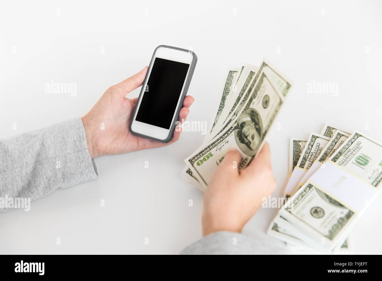 close up of hands with smartphone and dollar money Stock Photo
