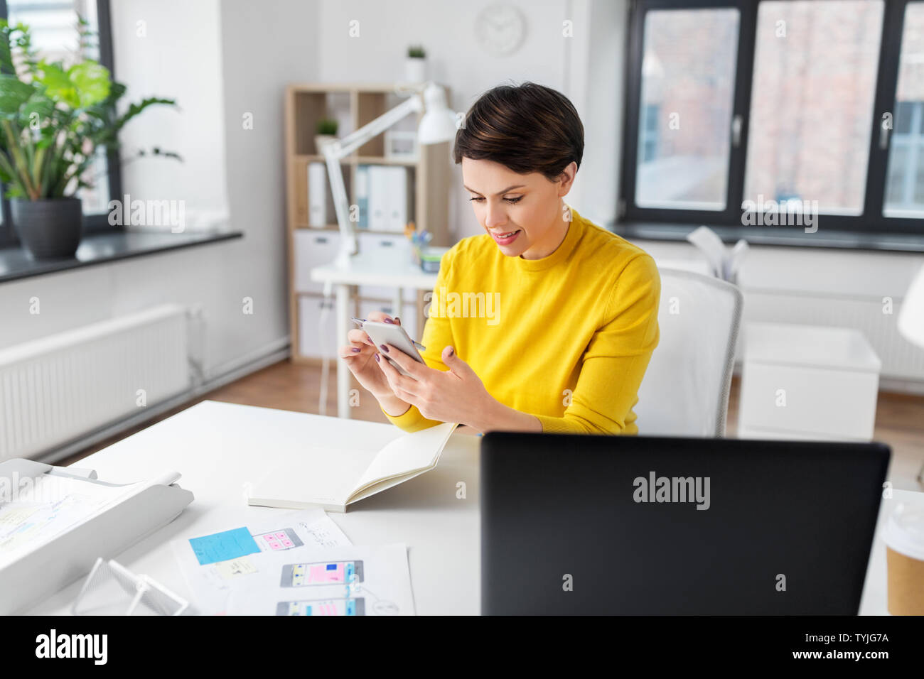 smiling ui designer using smartphone at office Stock Photo