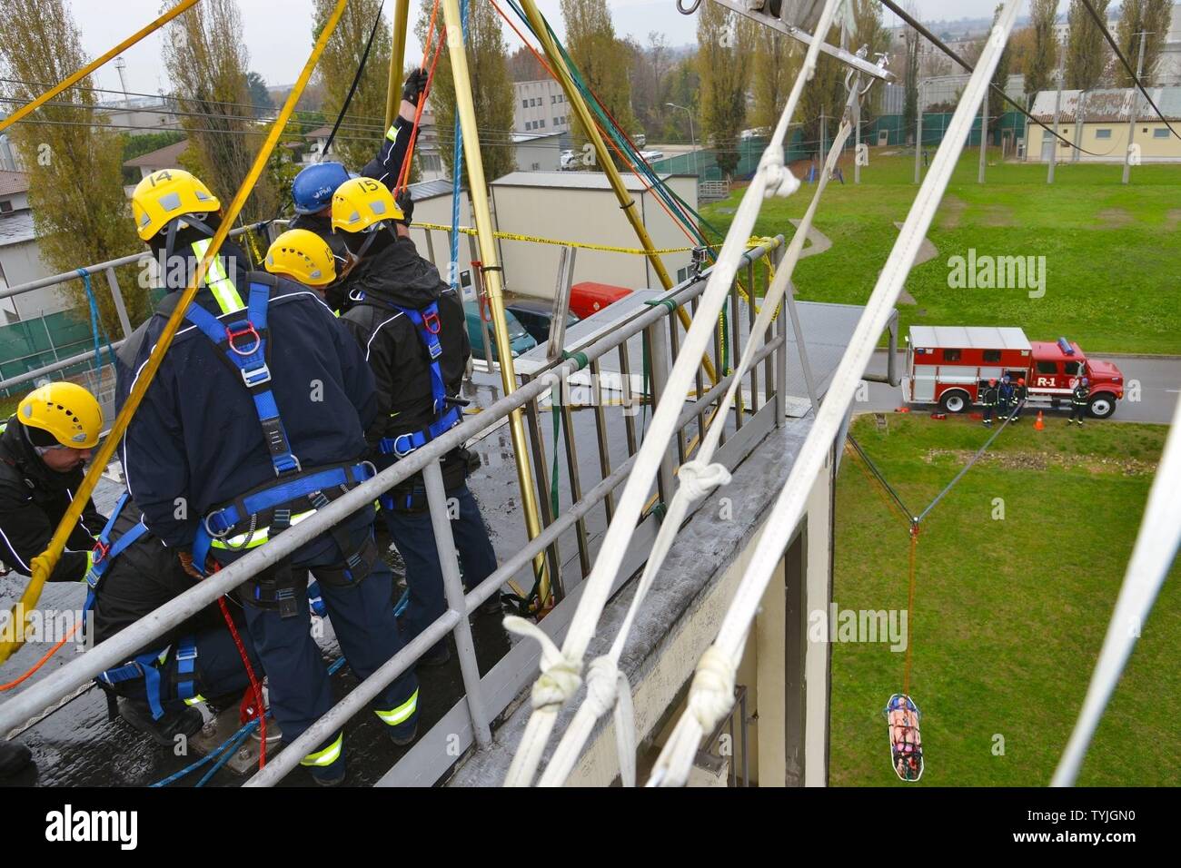 Firefighters assigned to the U.S. Army Garrison Italy, use rope work and knot tying techniques to ascend and extract a simulated injured victim at the Army Training Command tower, 34-feet high, during Department of Defense Technical Rope Rescue 1, Caserma Ederle, Vicenza, Italy, Nov. 11, 2016. Firefighters here received training from instructors from the 435th Construction and Training Squadron, Ramstein Air Base, Germany, on a variety of rescue techniques and scenarios including operational risk management, incident management system, ground support for helicopter operations and confined spac Stock Photo