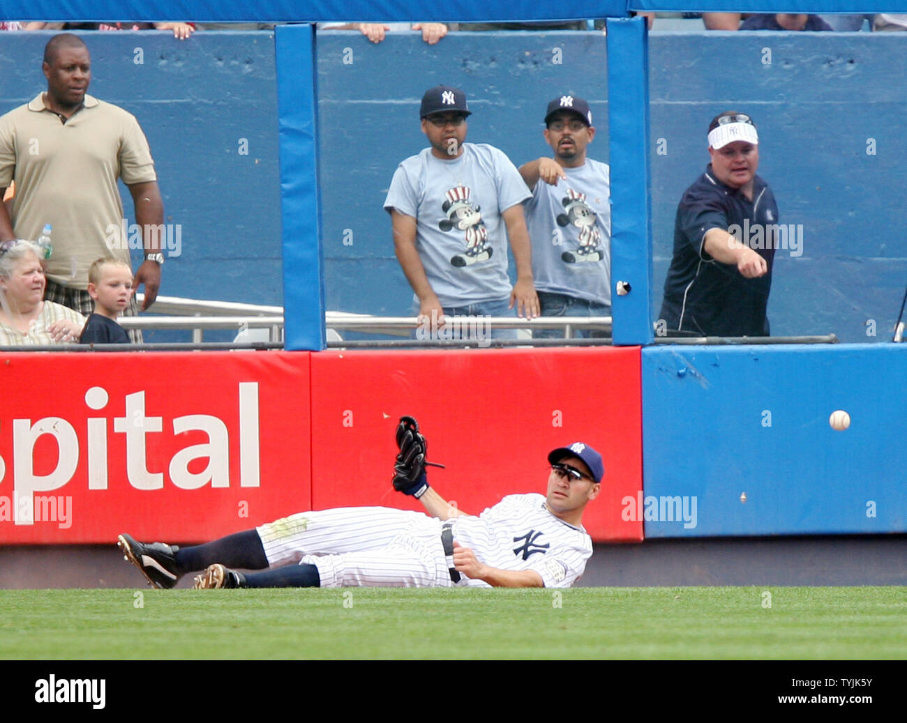 New York Yankees Johnny Damon watches the baseball fall to the ground after  leaping on the fence to make a play against the Boston Red Sox in the third  inning at Yankee, image size:1300x1037