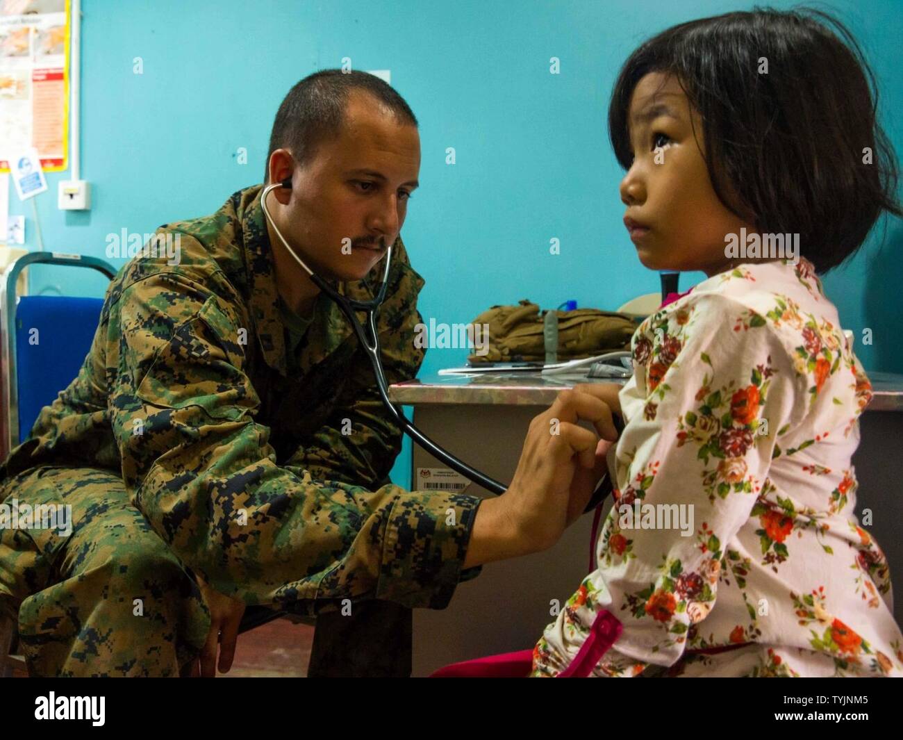 SABAH PROVINCE, Malaysia (November 11, 2016) – Lt. Russell Paloian, a medical officer, examines the heartbeat a of a child during a medical civil affairs project during Exercise Tiger Strike 2016 in Sabah Province, Malaysia, Nov. 11. U.S. Navy and Malaysian medical personnel worked together in a medical capabilities exchange which gave the Navy medical team the opportunity to work together with local medical professionals to give care and treatment to local Malaysians. Paloian is with Combat Logistics Battalion 11. Stock Photo