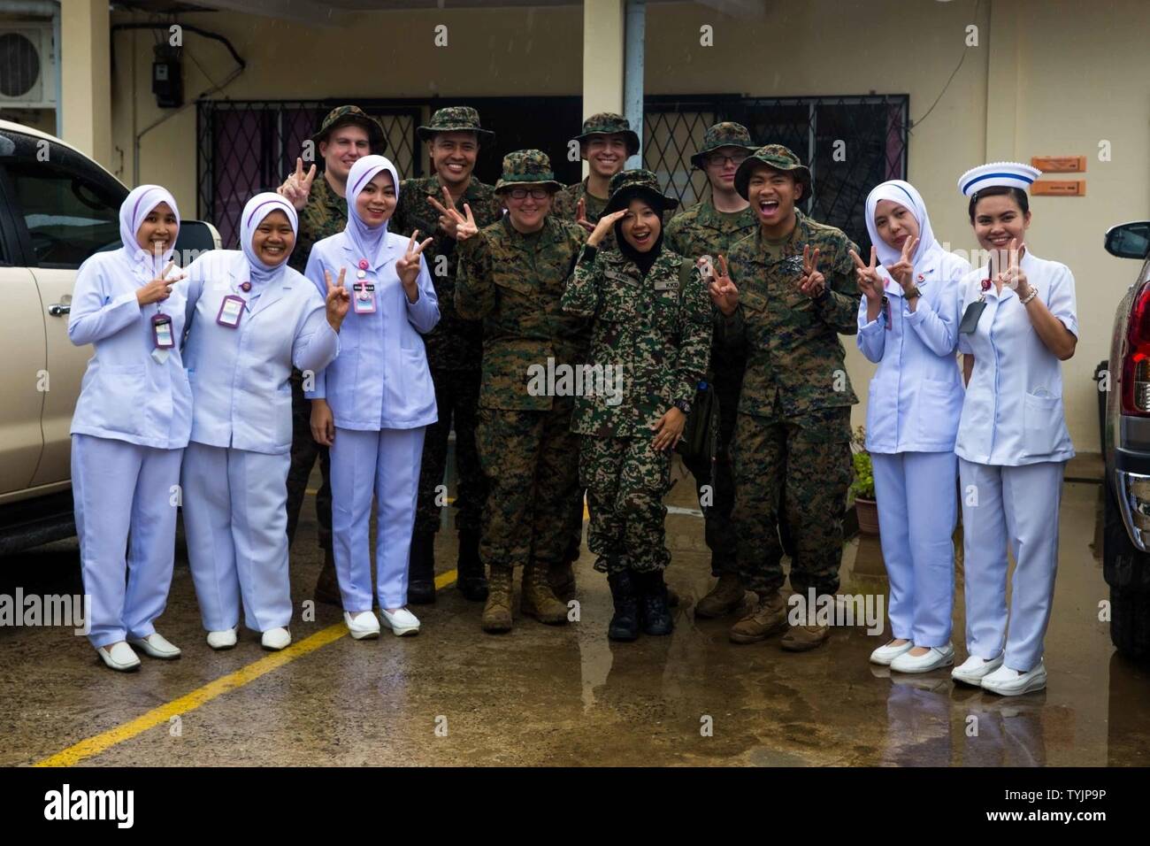 SABAH PROVINCE, Malaysia (November 11, 2016) – U.S. Navy, Malaysian Armed Forces and local Malaysian medical professionals pose for a picture after a medical civil affairs project during Exercise Tiger Strike 2016 in Sabah Province, Malaysia, Nov. 11. During the project, the local Malaysian nurses gave the Navy personnel a tour of the clinic and discussed their daily operations. The Navy personnel are with Combat Logistics Battalion 11, 11th Marine Expeditionary Unit. The 11th MEU, part of the Makin Island Amphibious Ready Group, is operating in the U.S. 7th Fleet area of operations in support Stock Photo