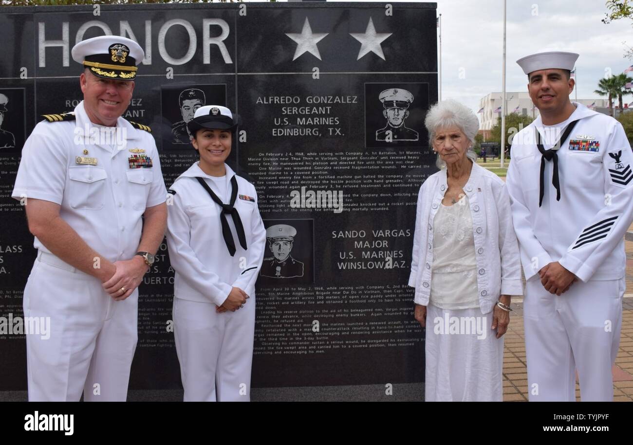 Texas (Nov. 16, 2016) Cmdr. Stefan L. Walch, (left) commanding officer of Areligh Burke-class, guided-missile destroyer USS Gonzalez (DDG 66), Petty Officer 2nd Class Katherine Lira (second from left),  Ms. Dolia Gonzalaz, and Petty Officer 1st Class William Mireles (Right) pay respects to Sgt. Alfredo Gonzalez at the Veterans War Memorial of Texas. Stock Photo