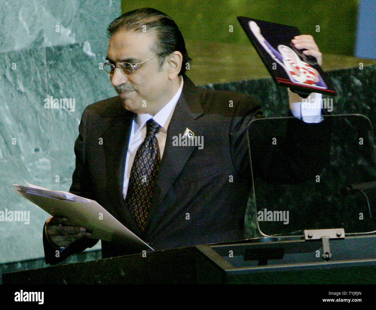 Asif Ali Zardari, President of Pakistan and husband of Benazir Bhutto, removes the photo of the assassinated political leader which he placed on the podium while addressing the 63rd session of the General Assembly at the United Nations on September 25, 2008 in New York City. (UPI Photo/Monika Graff) Stock Photo