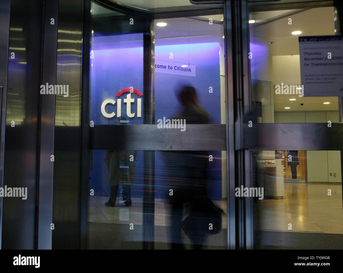 People Walk Through A Revolving Glass Door To Enter A Branch Of Citibank Located On The People Walk Through A Revolving Glass Door To Enter A Branch Of Citibank Located On The
