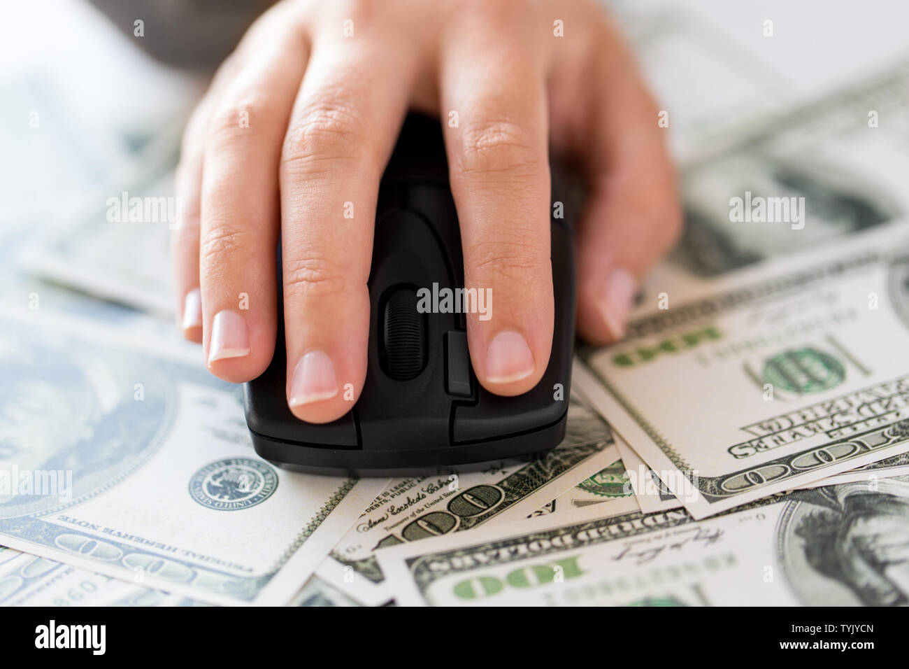 close up of hand with computer mouse on money Stock Photo