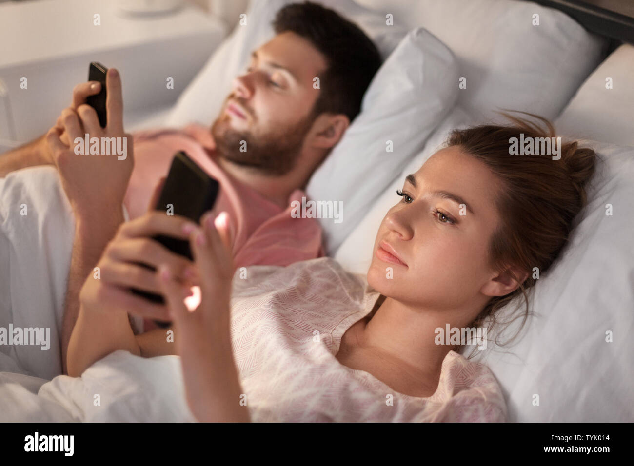 couple using smartphones in bed at night Stock Photo Alamy