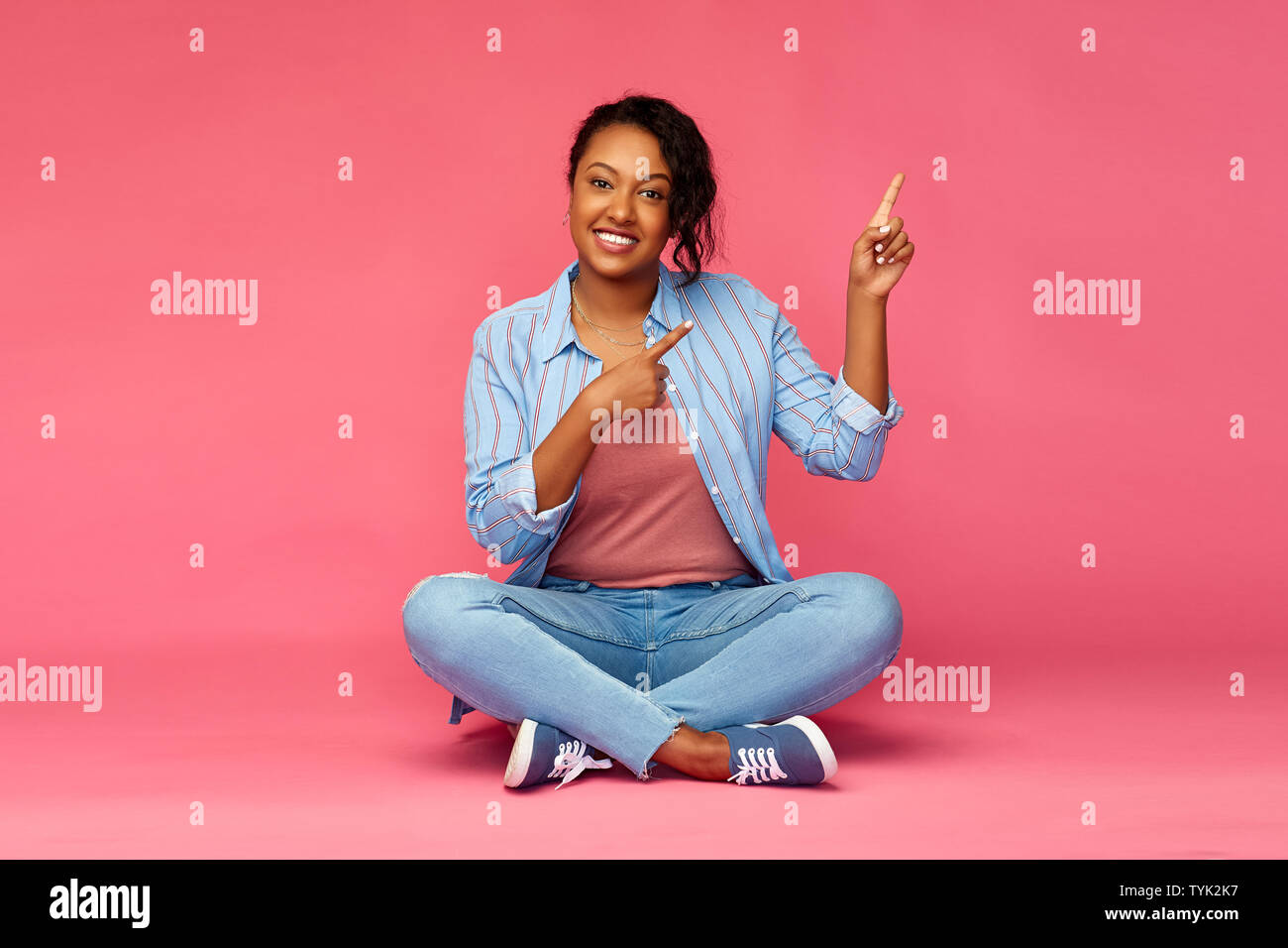 happy african american woman pointing fingers up Stock Photo - Alamy