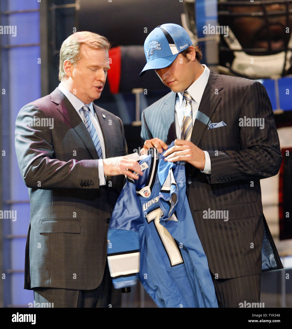 Georgia quarterback Matthew Stafford walks down an isle holding a