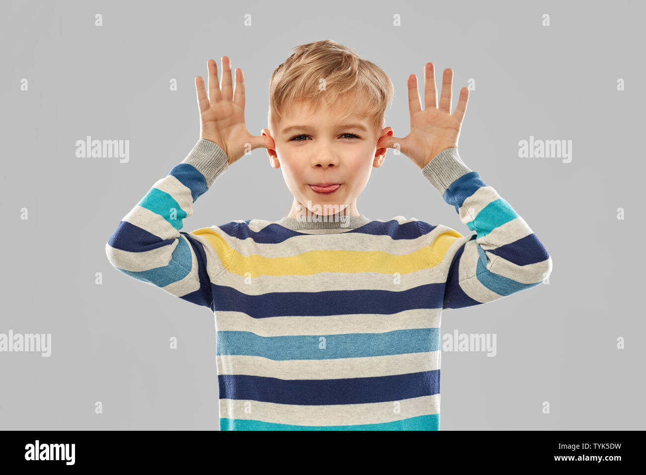 little boy in red t-shirt making big ears by hands Stock Photo