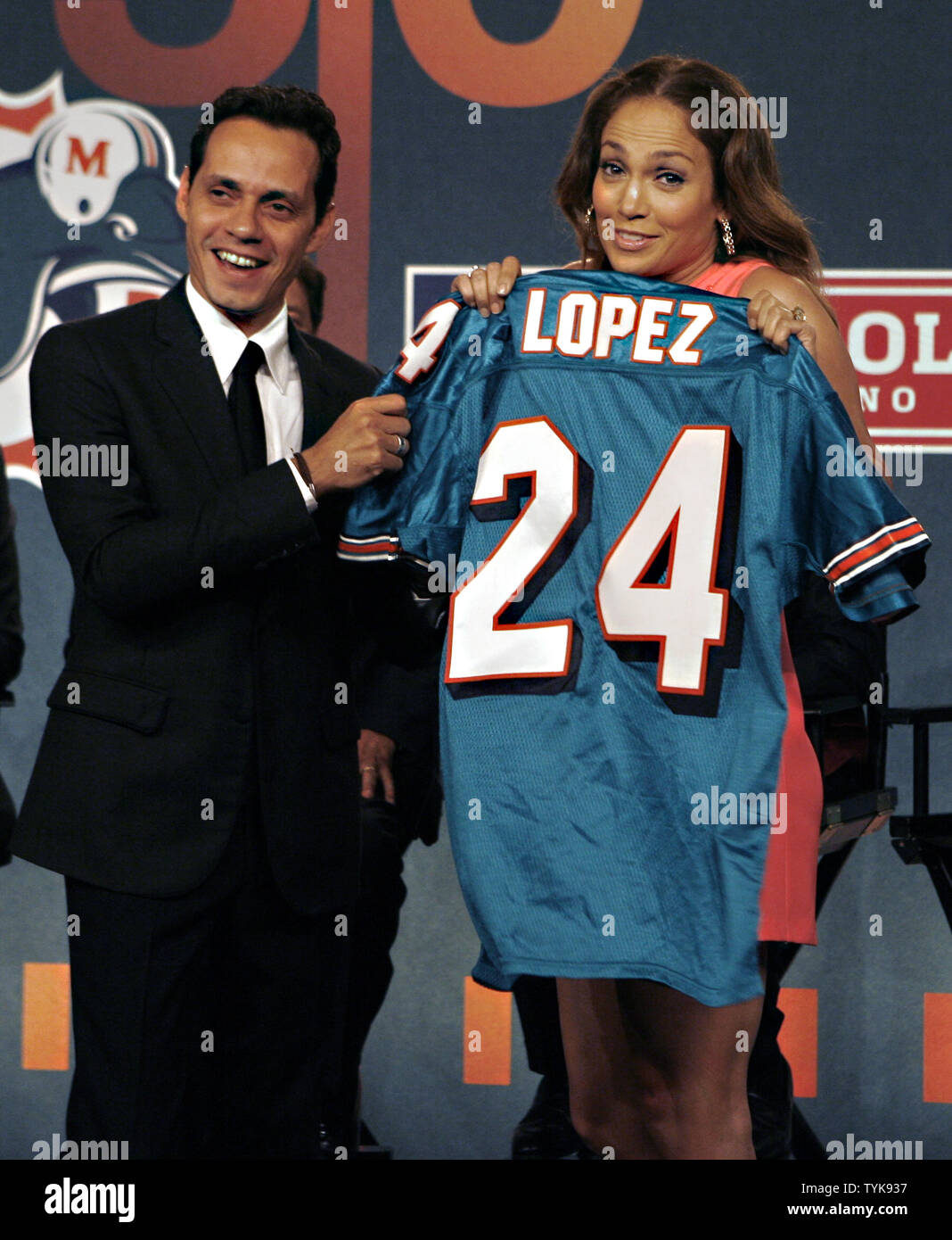 Jennifer Lopez and Marc Anthony hold up Miami Dolphins Jerseys on the stage  at the NFL, ESPN/ESPN Deportes and the Miami Dolphins press conference to  announce Marc Anthony as part owner of