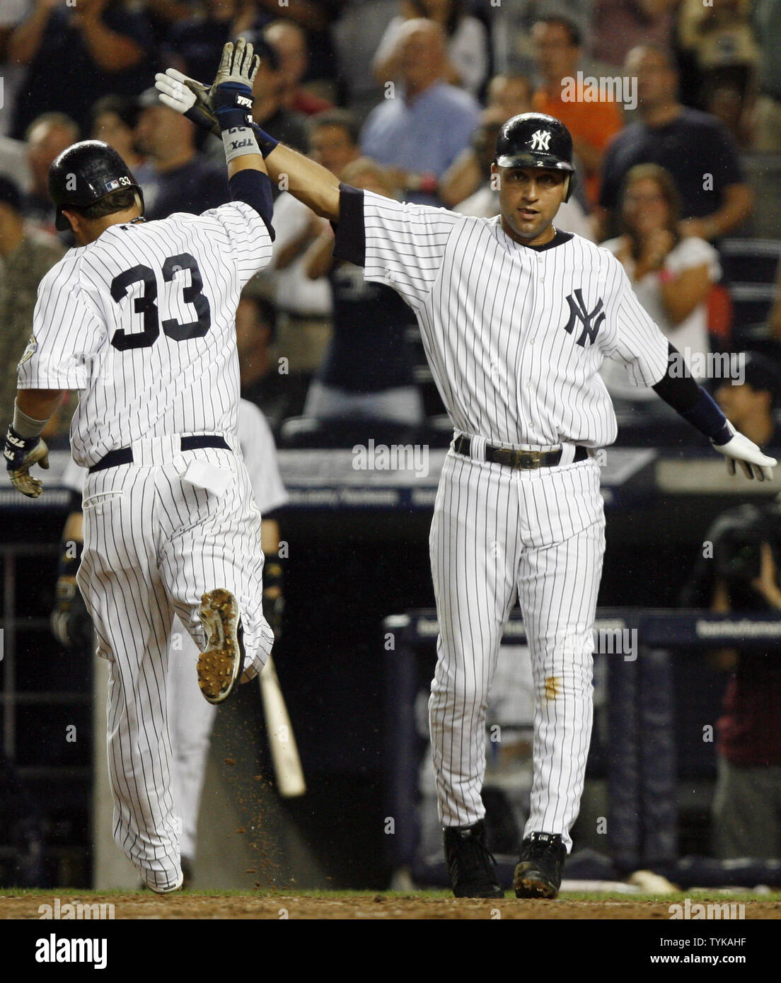 New York Yankees Nick Swisher (33) slaps hands with Derek Jeter after crossing home plate in the seventh inning against the Texas Rangers at Yankee Stadium in New York City on August 26, 2009.          UPI/John Angelillo Stock Photo