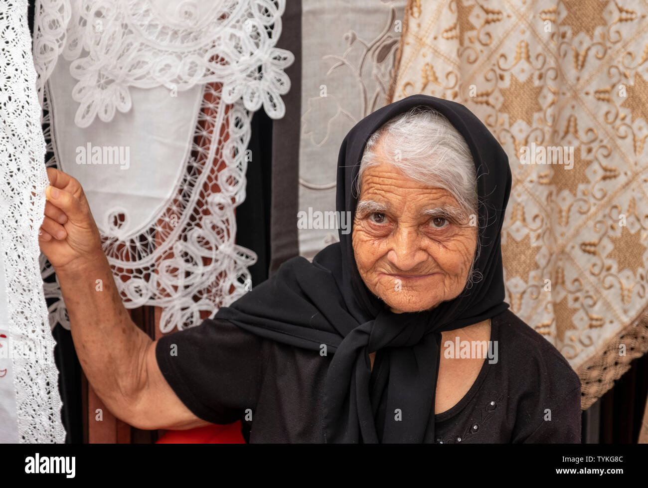 A lady selling lace at a market stall in Paphos old town, Cyprus. Stock Photo