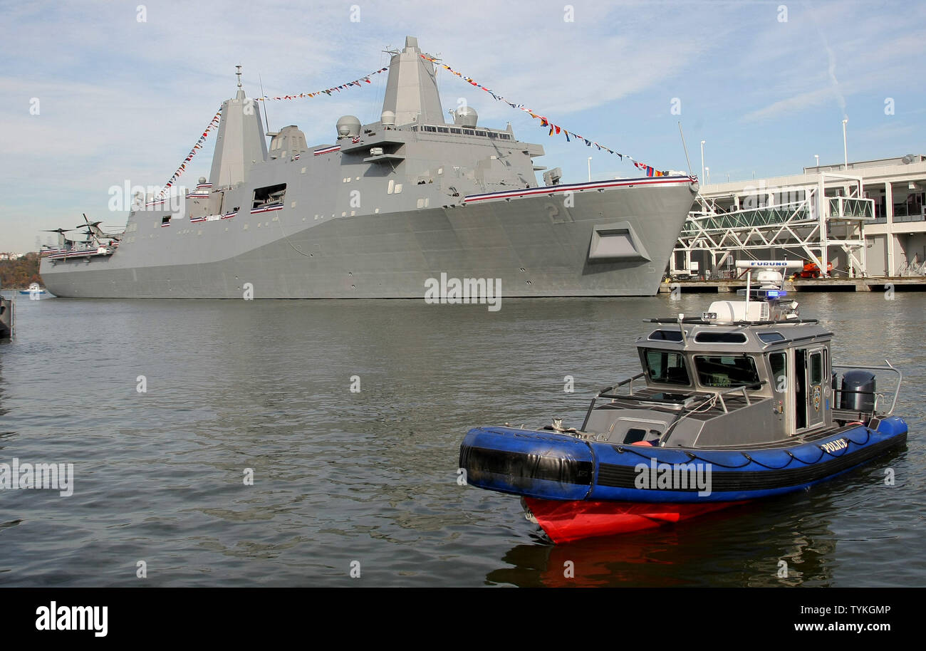 A police patrol boat floats by the USS New York which is to be ...