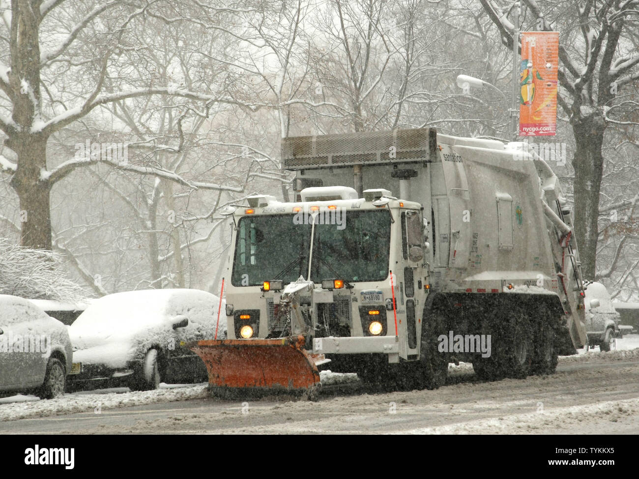 A garbage truck with a plow attached to its front is used to clear the