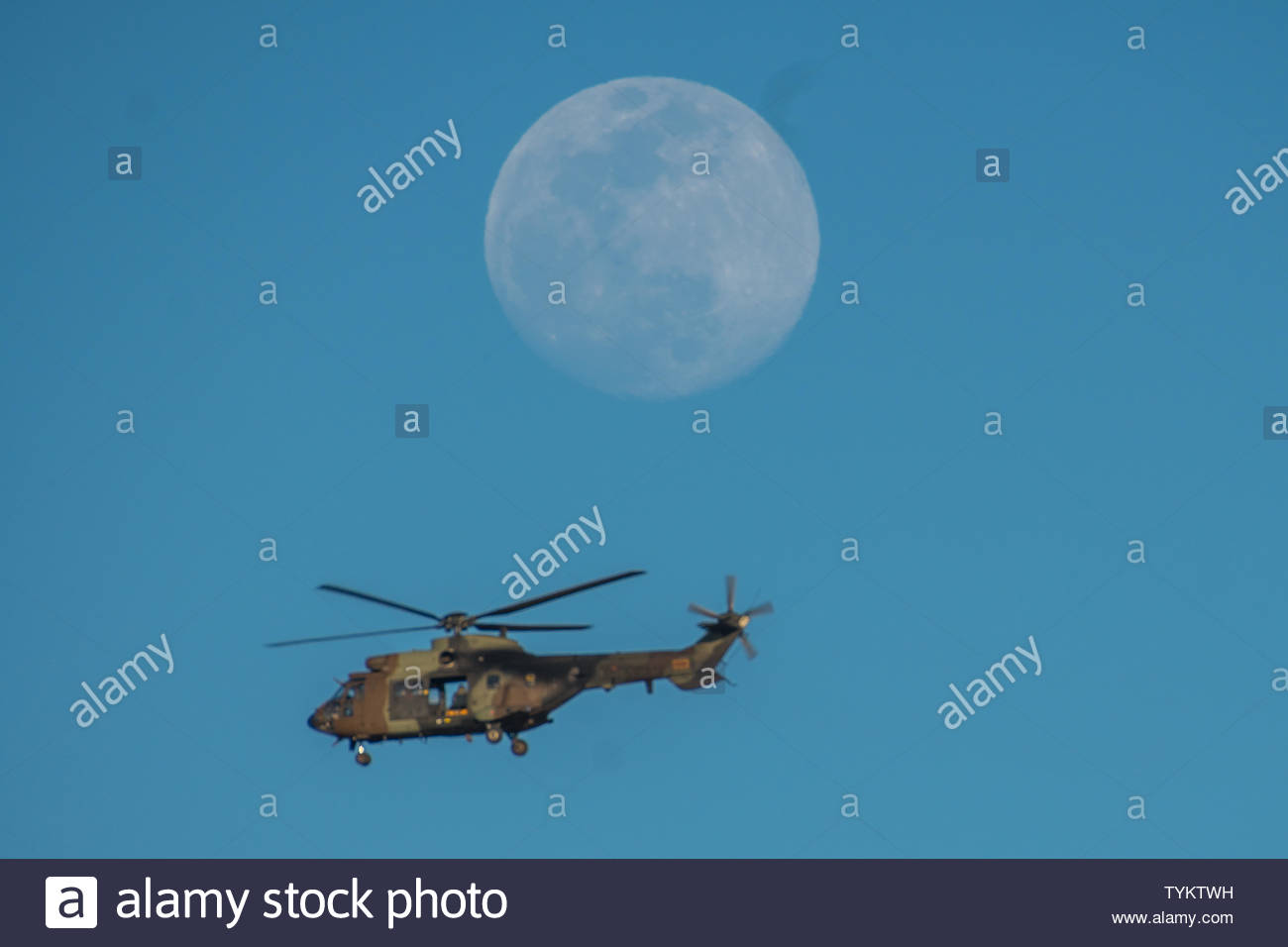 Military Helicopter Flying In Front Of A Full Moon At Dusk In A Side View With Door Open Stock Photo Alamy