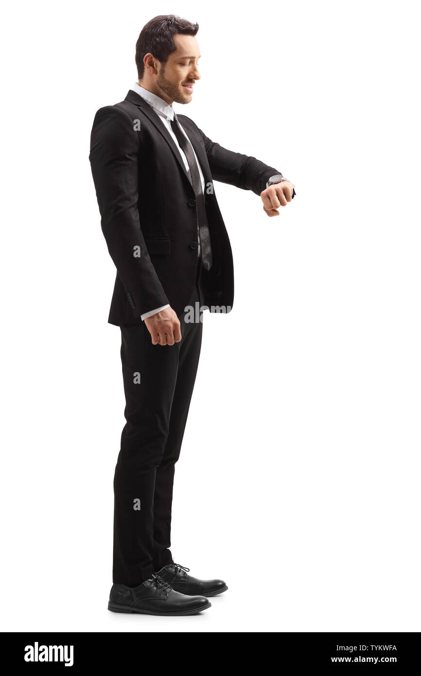 Full length profile shot of a businessman in a suit looking at his wrist watch isolated on white background Stock Photo