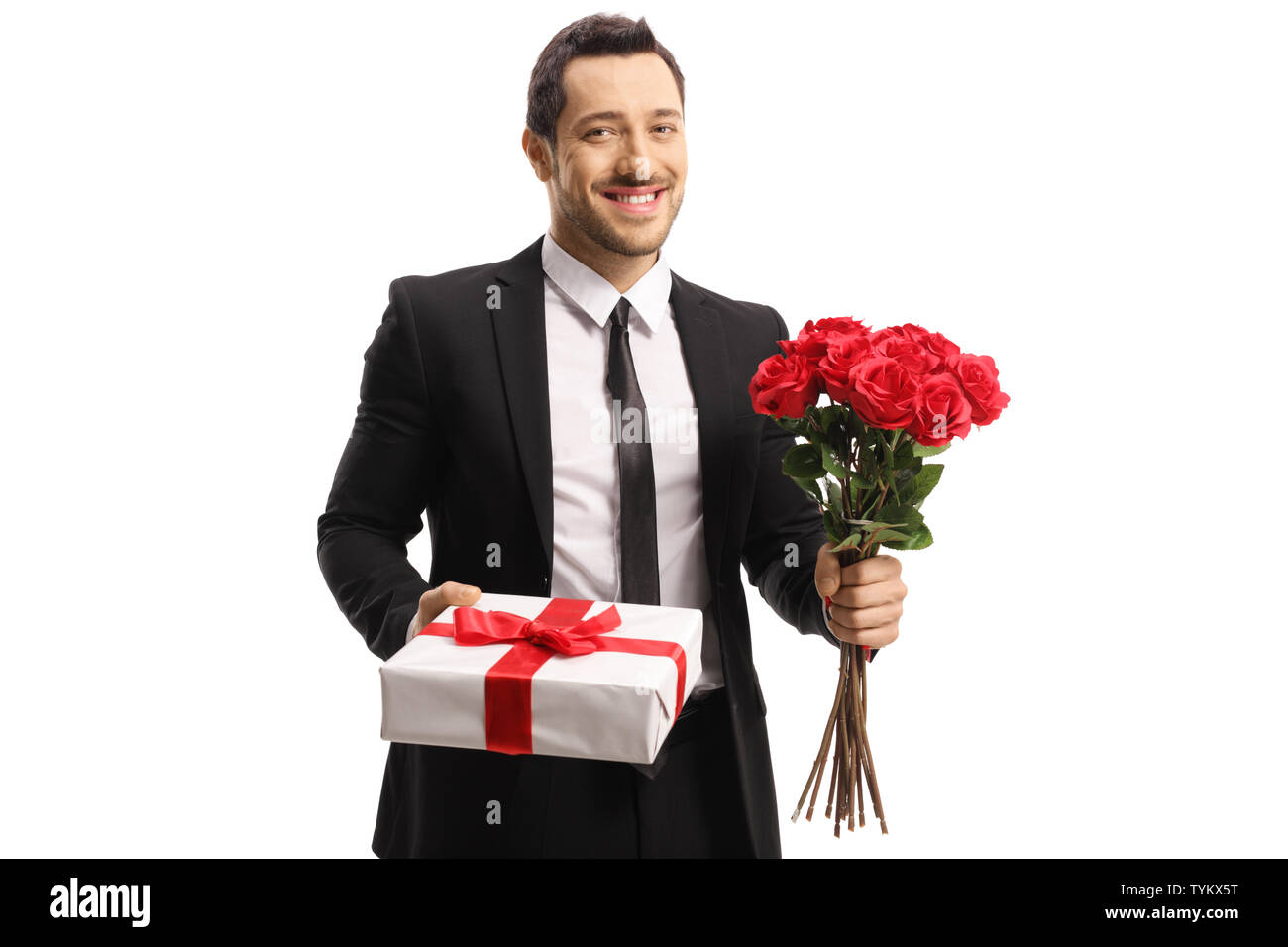Handsome young man holding a bunch of red roses and a present isolated ...