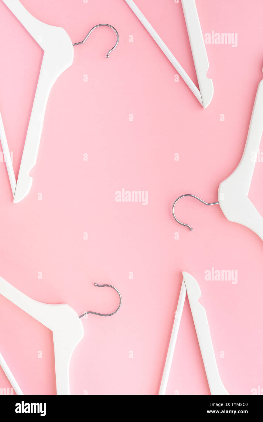 Creative top view flat lay white wooden hangers pastel millennial pink ...