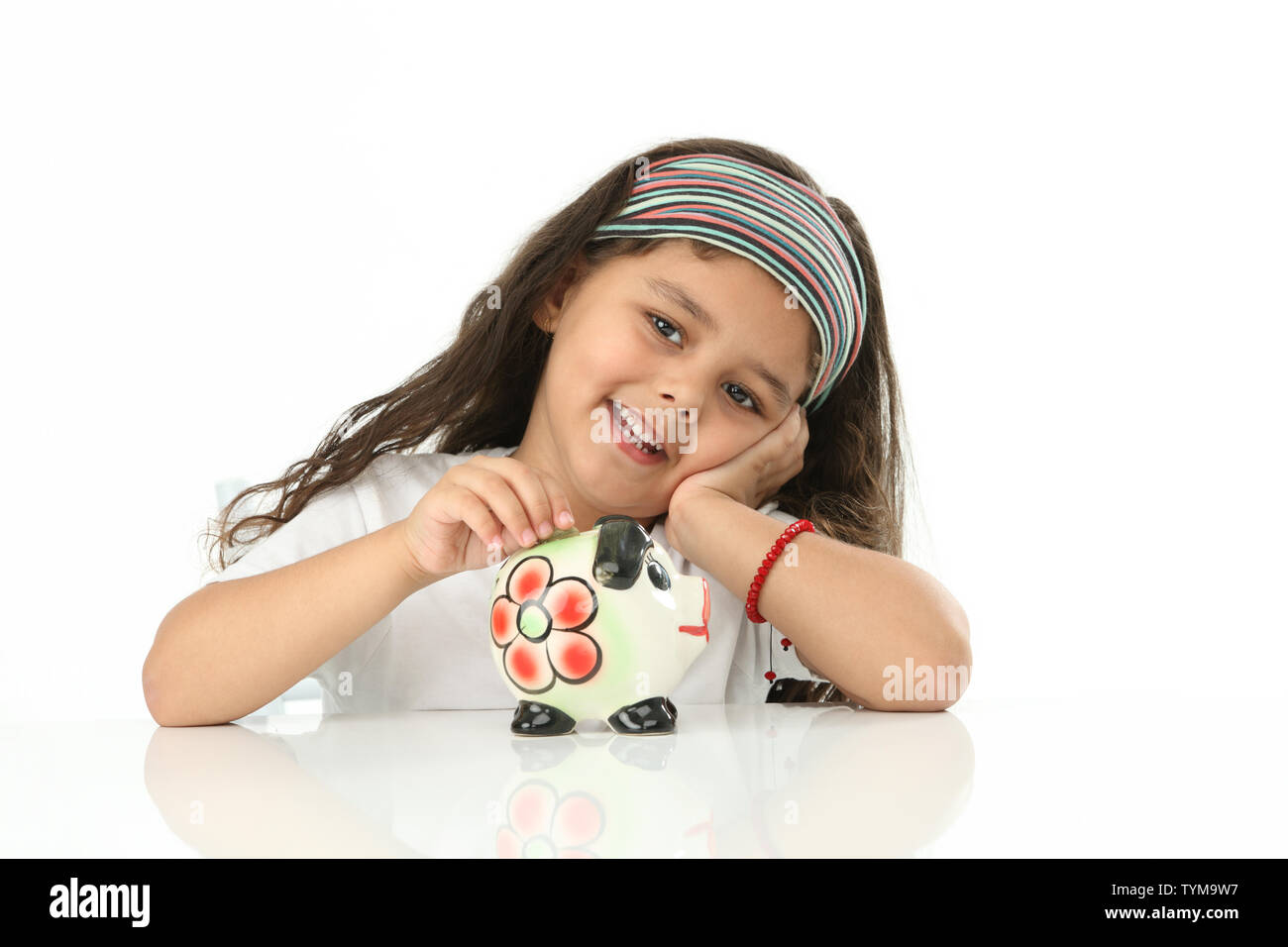 Girl putting coin into a piggy bank Stock Photo - Alamy