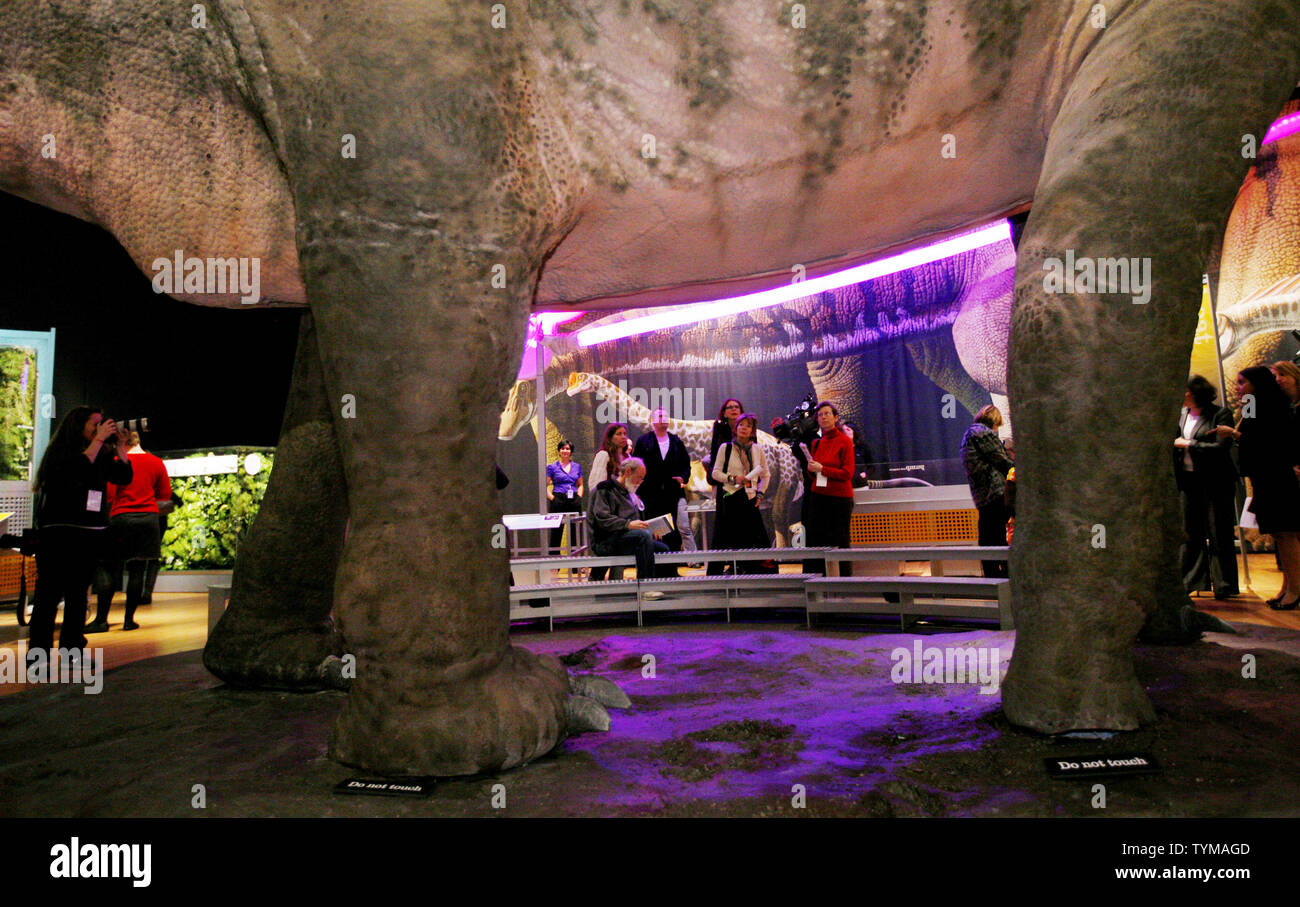 People are seen beyond the massive legs of the lifesized model of a 60