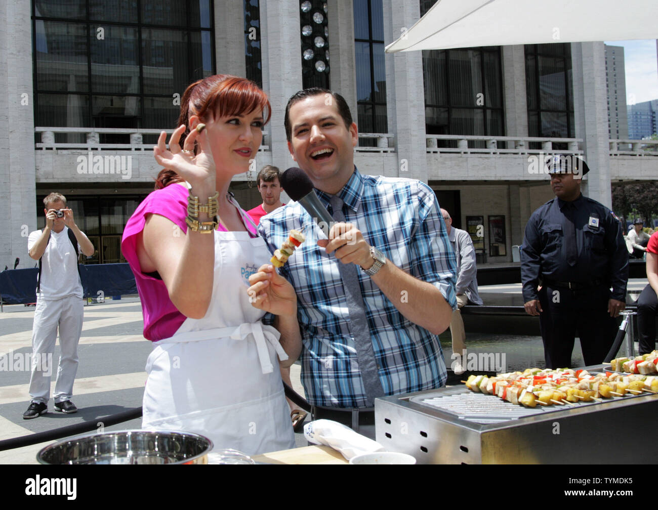 Ross Matthews and Sara Rue serve and cook food at the Jenny Craig 'Jenny's Party in the Plaza' at Josie Robertson Plaza at Lincoln Center in New York on June 14, 2011.       UPI /Laura Cavanaugh Stock Photo