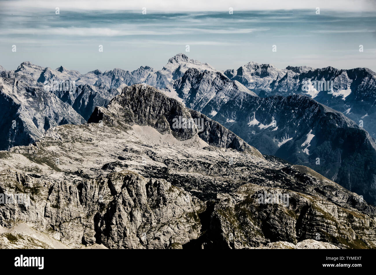 Creative dramatic mountain landscape with high peaks and sharp rocks. View from Kanin to Triglav in Slovenia. Stock Photo