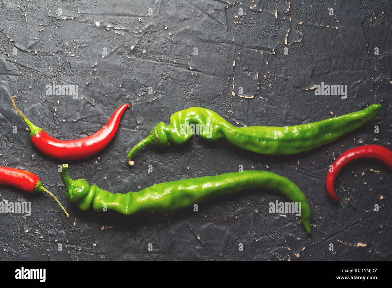 Pods of green and red hot peppers on a dark textured background Stock ...