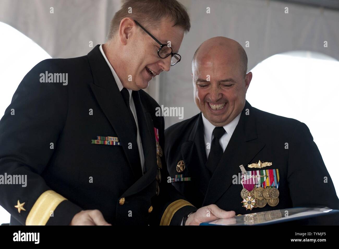 NORFOLK, Va. (November 16, 2016)  Rear Adm. Brian Luther shares a laugh with Capt. Juan J. Orozco, former commanding officer of the guided-missile cruiser USS Leyte Gulf (CG 55), after awarding him the Legion of Merit in recognition of his service. Capt. Daniel D. Sunvold relieved Orozco as the commanding officer in a ceremony held aboard on the ship's fantail. Stock Photo
