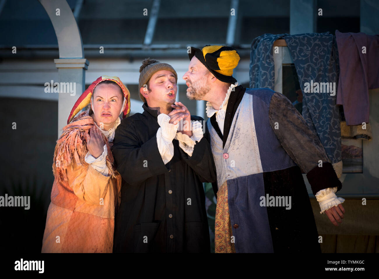 Actors Katy Helps, Chris Wills and David Sayers performing the roles of Trinculo, Caliban and Stephano in an outdoor theatre production of The Tempest Stock Photo