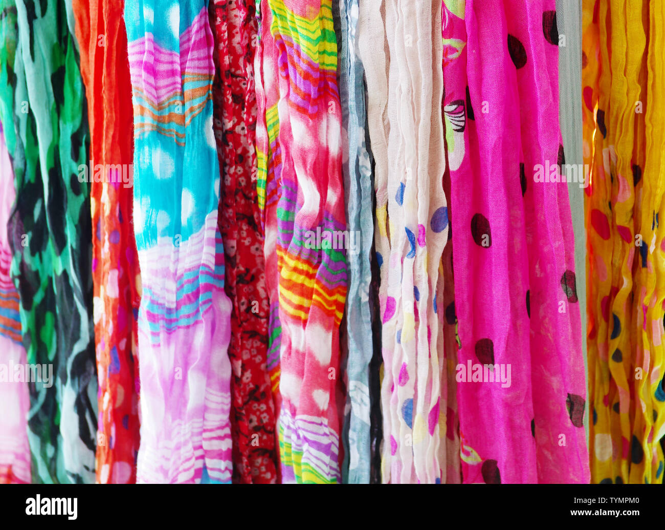 Many colorful linen scarfs hanging for sale Stock Photo