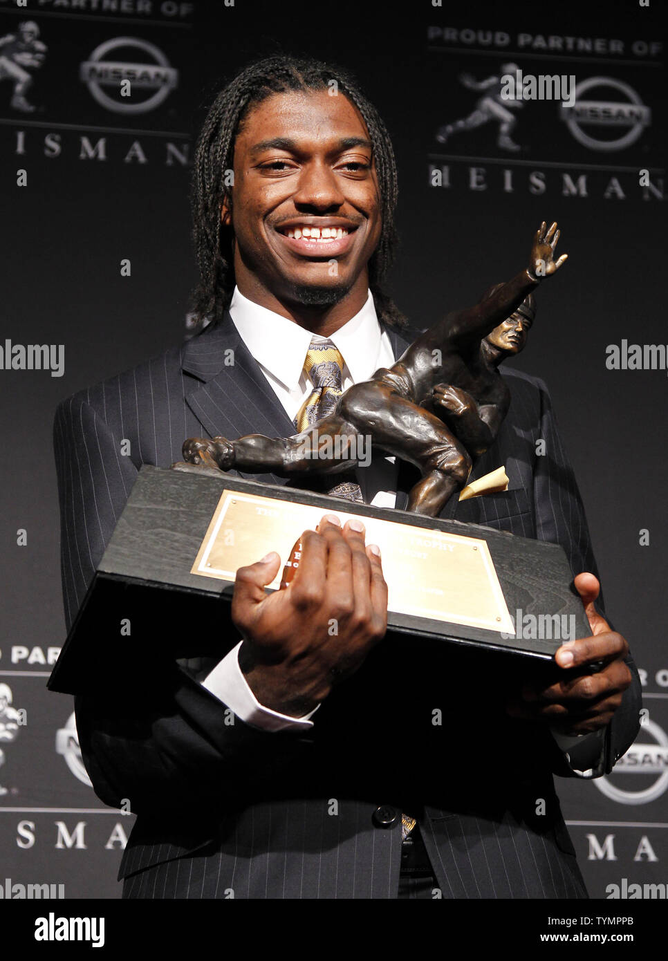 Baylor quarterback Robert Griffin III stands on the stage holding