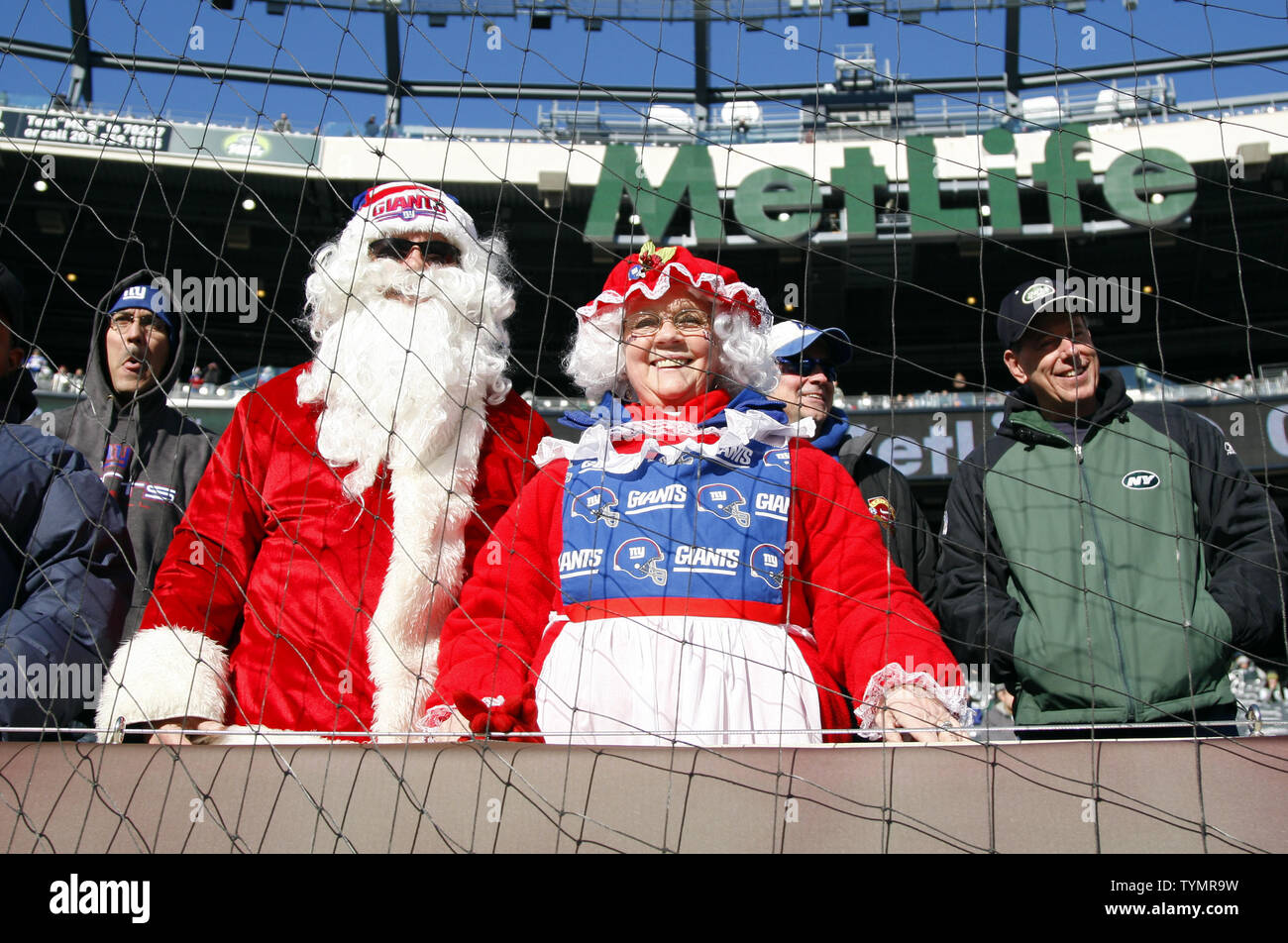 Football fans dressed as Mr. and Mrs. Santa Clause watch the New York Jets  play the New York Giants game in week 16 of the NFL season at MetLife  Stadium in East